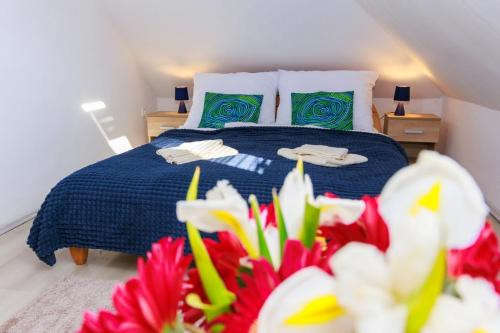 a bedroom with a blue bed with green and red flowers at Retel Vitez Vendégház in Sárospatak