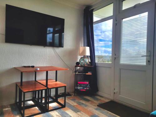 Cette chambre dispose d'une télévision, d'une table et d'une fenêtre. dans l'établissement Charming 2 Bedroom Holiday Chalet, à Withernsea