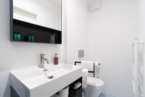 a white bathroom with a sink and a toilet at Art Hotel Tartini in Piran