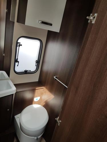 a small bathroom with a toilet and a sink at FORD ZEFIRO 675 MOTORHOME in Wigan