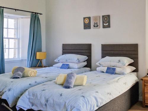 2 nebeneinander sitzende Betten in einem Schlafzimmer in der Unterkunft Key House in Falkland