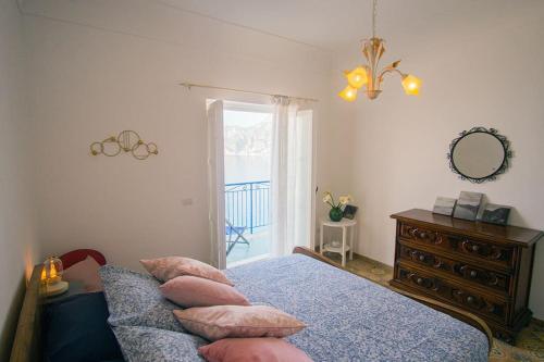 um quarto com uma cama, uma cómoda e um espelho em Mimì Junior home, central sea view apartment em Praiano