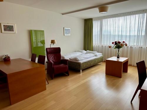 sala de estar con cama, sofá y silla en Golf & Relax Apartment mit 4*S-Anbindung, en Bad Waltersdorf
