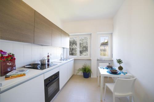 a kitchen with white counters and a table and chairs at Dreams Hotel Residenza Gambara in Milan