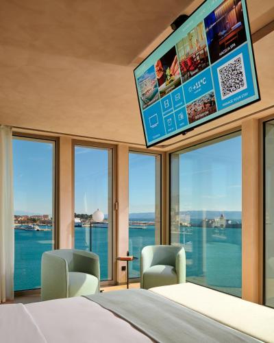 a bedroom with a large window with a tv at Hotel Ambasador in Split