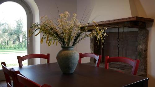 a vase with flowers on a table in a room at Agriturismo I Due Casali in Vetralla