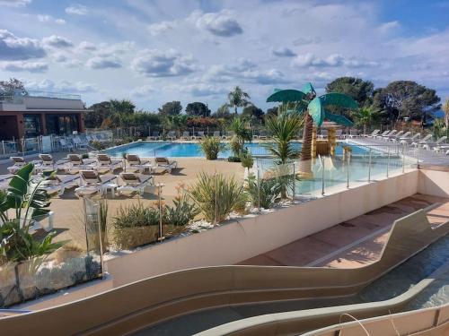 un complexe avec une piscine entourée de chaises et d'un parasol dans l'établissement Blue Horizon, à Saint-Raphaël