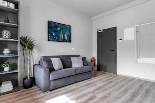 een woonkamer met een grijze bank en een deur bij B18 Apartments in Reykjavík