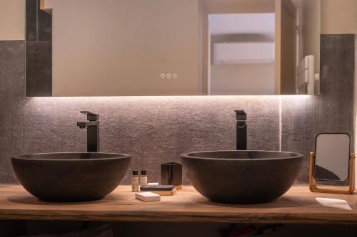two sinks on a counter in a bathroom at Hôtel Restaurant Le Fiacre à Quend plage in Quend
