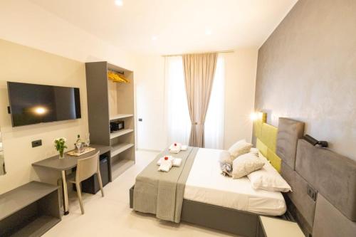 Dormitorio con cama, escritorio y TV en Affittacamere Flori, en La Spezia