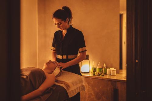 a woman is giving a woman a massage at Coeur de Megève in Megève
