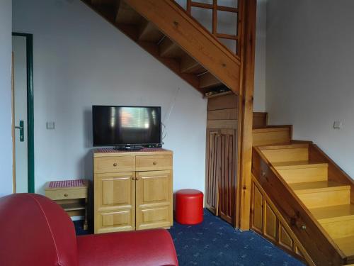 a living room with a tv and a staircase at Zlatiborski Kutak in Zlatibor