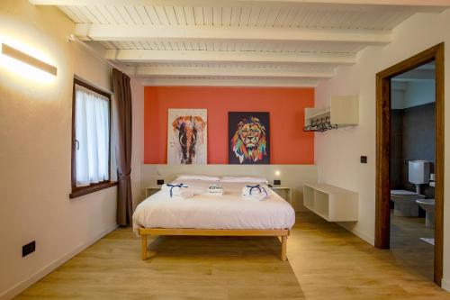 a bedroom with a bed with an orange wall at Le Tofane, vivi la bellezza di Belluno - Ciclamino in Sòis