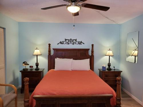 1 dormitorio con 1 cama con colcha roja en Dons Bonita Beach Tennis Club, en Bonita Springs