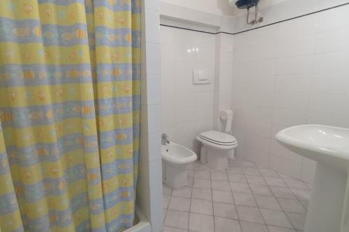 a bathroom with a toilet and a shower curtain at Appartamenti Seccione in Portoferraio