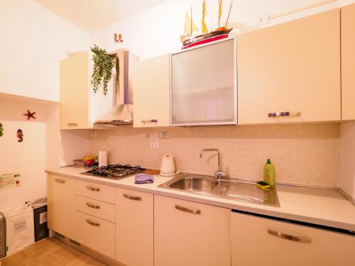 a kitchen with white cabinets and a sink at Casa Pina Quiet Apartment in Vernazza
