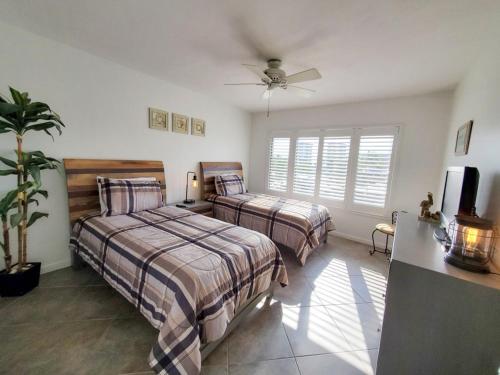 a bedroom with two beds and a ceiling fan at Freds Santa Maria Harbour Resort Condo in Fort Myers Beach