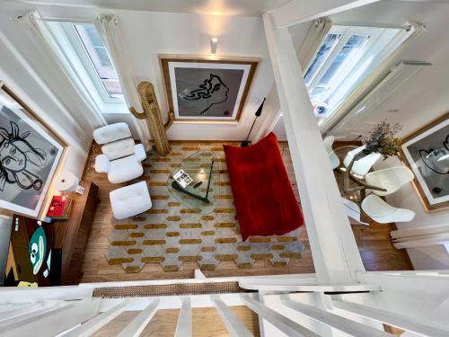 an attic room with a red couch and a table at La Petite Adresse du 10Honfleur in Honfleur
