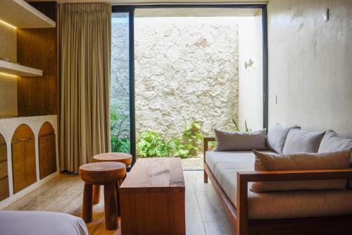a living room with a couch and a large window at Eterna Tulum in Tulum