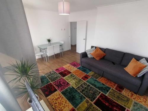 a living room with a couch and a rug at White City Apartment, your London stay in London
