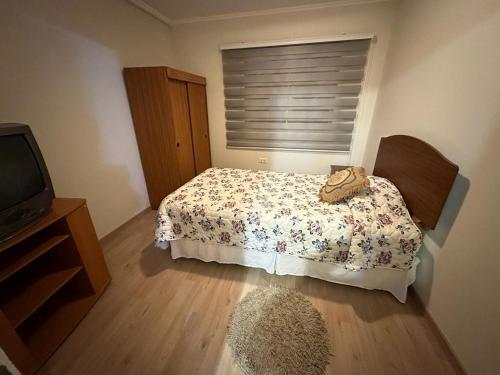 sypialnia z łóżkiem i telewizorem w obiekcie Casa 3 dormitorios Coquimbo w mieście Coquimbo