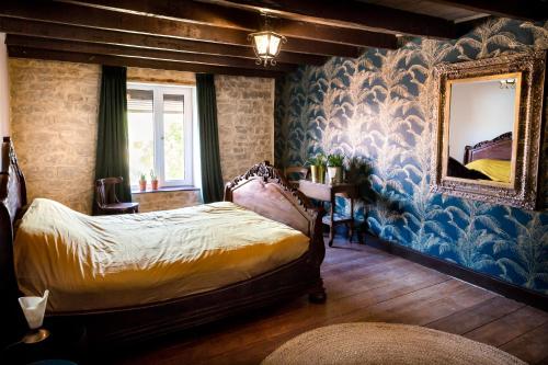 een slaapkamer met een bed en een blauwe muur bij Gite une belle Histoire in Voisey