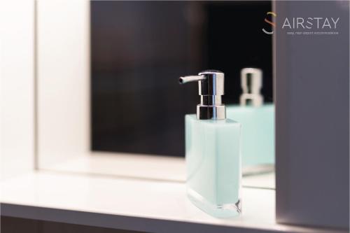a bathroom sink with a soap dispenser in front of a mirror at Elise Apartment Airport by Airstay in Spáta