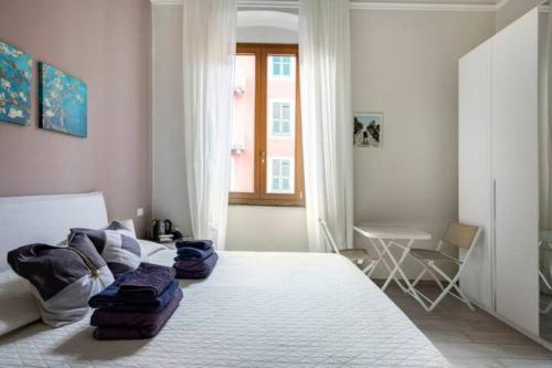 sypialnia z dużym białym łóżkiem i stołem w obiekcie Big Central Room w mieście La Spezia