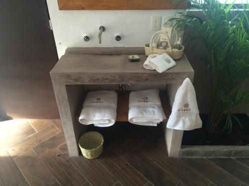 a table with towels and a sink in a room at Mocca Hotels in Tepoztlán
