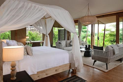馬賽馬拉的住宿－JW Marriott Masai Mara Lodge，一间卧室配有一张带天蓬的床