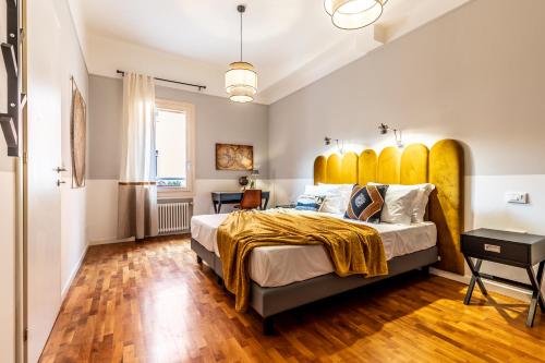 a bedroom with a large bed with a large yellow headboard at HouSmart Capo di Lucca 1 in Bologna