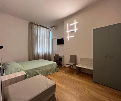 a bedroom with two beds and a cross on the wall at Hotel Villa Primavera in Pisa