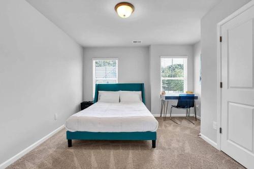 um quarto com uma cama, uma mesa e janelas em The GoodLiving Experience (Entire Town House) em Atlanta