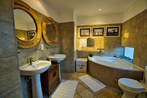 uma casa de banho com 2 lavatórios, uma banheira e um WC. em Atlantic Waterfront Cottage D3, 3 bedroom sea view em Swakopmund