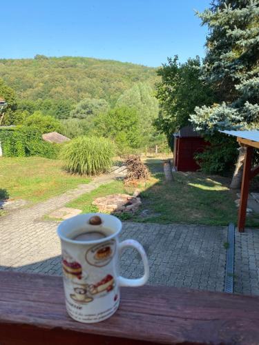 Sziszi Vendégház في Kovácsszénája: وجود كوب قهوة على طاولة خشبية