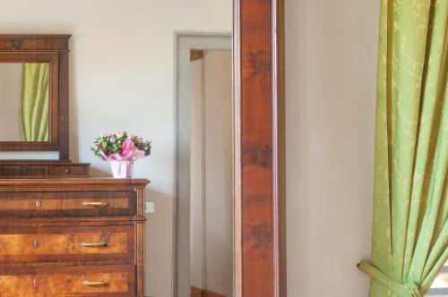 a mirror next to a dresser with a vase of flowers at Universal Harmony - Usignolo in Dicomano