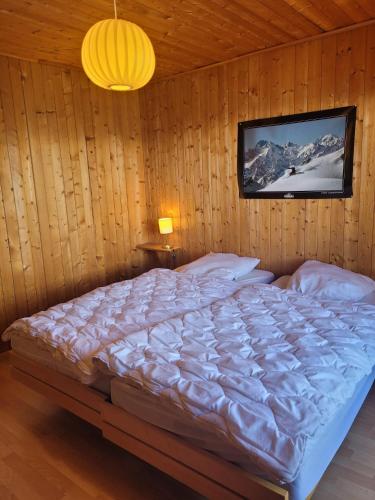 a bedroom with a large bed in a wooden wall at La Crettaz app dans chalet - SUNNY apartment 6 p in Veysonnaz