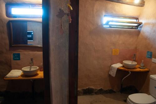 a bathroom with two sinks and a toilet at KONDUR ELEMENTOS ECO HOSTEL in Las Compuertas