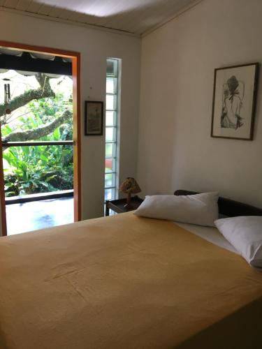 a bedroom with a large bed and a window at Casa da árvore in Ubatuba