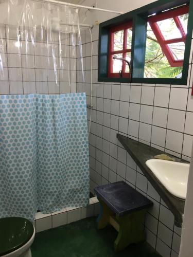 a bathroom with a sink and a toilet and a shower at Casa da árvore in Ubatuba