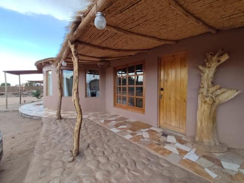 una casa con dos árboles delante de ella en Cabañas Larache, en San Pedro de Atacama