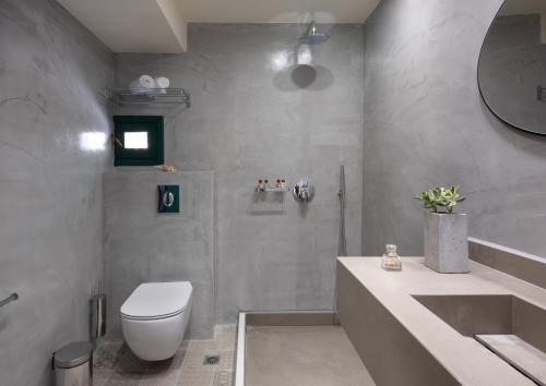 een badkamer met een wit toilet en een wastafel bij Kalimera Village in Chersonissos