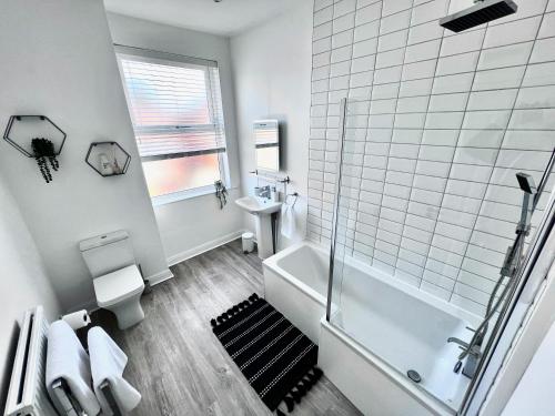 a bathroom with a shower and a toilet and a sink at House in Manchester in Manchester