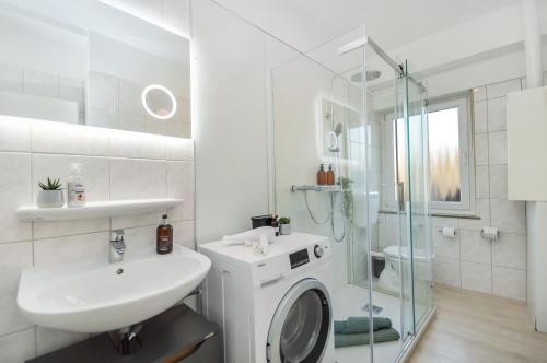 a white bathroom with a sink and a shower at AT WEINMEISTER - Gemütlichkeit & Ruhe in Gütersloh