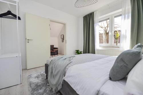 Un dormitorio con una cama grande y una ventana en Gemütliche & stylische Wohnung - Küche - Wifi - TV en Gütersloh