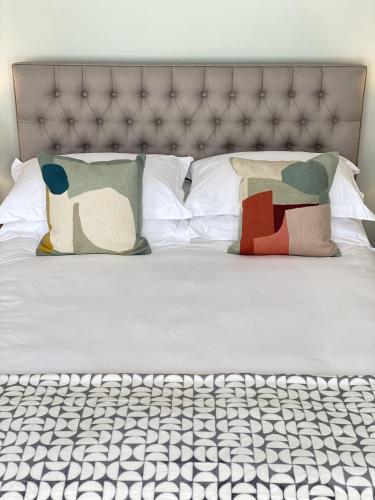 a bed with pillows on it with white sheets at Spacious, seaside, Victorian home "Bay View Terrace", Penzance in Penzance