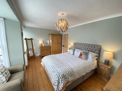 a bedroom with a large bed and a couch at Spacious, seaside, Victorian home "Bay View Terrace", Penzance in Penzance