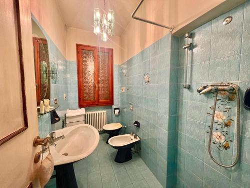 y baño de azulejos azules con lavabo y ducha. en [Monzuno] Elegante Suite, en Monzuno