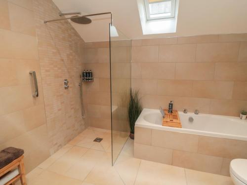 a bathroom with a shower and a tub and a sink at Garthgate Holiday Lodge in Malton