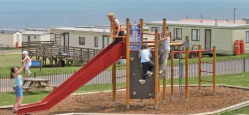 een groep kinderen die spelen op een speelplaats bij Crimdon dean park in Horden